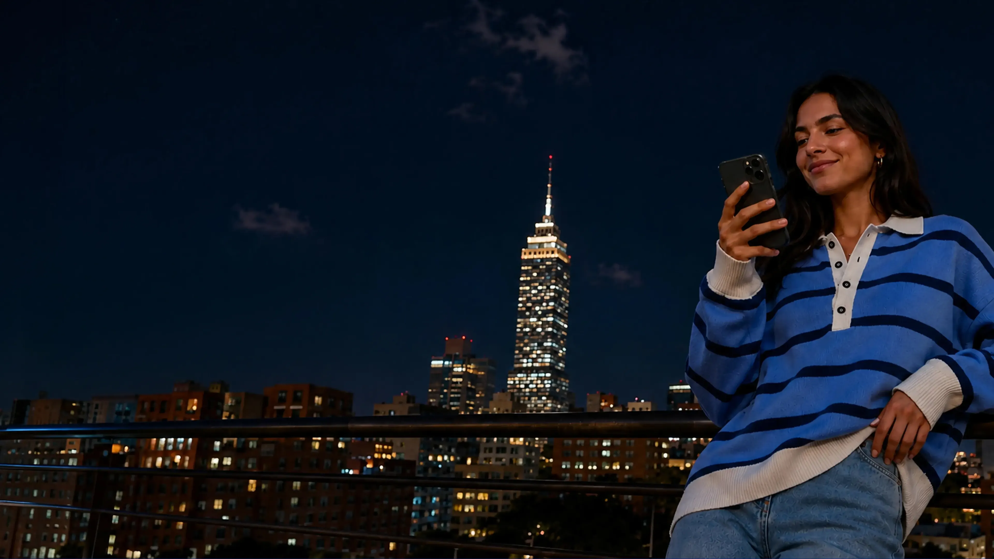 Mujer con celular, de fondo la ciudad de méxico.