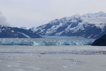 A small boat among icebergs at a glacier face