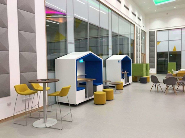 Shared office space with acoustic furniture for focused work in a custom modern office design that matches a company's brand image