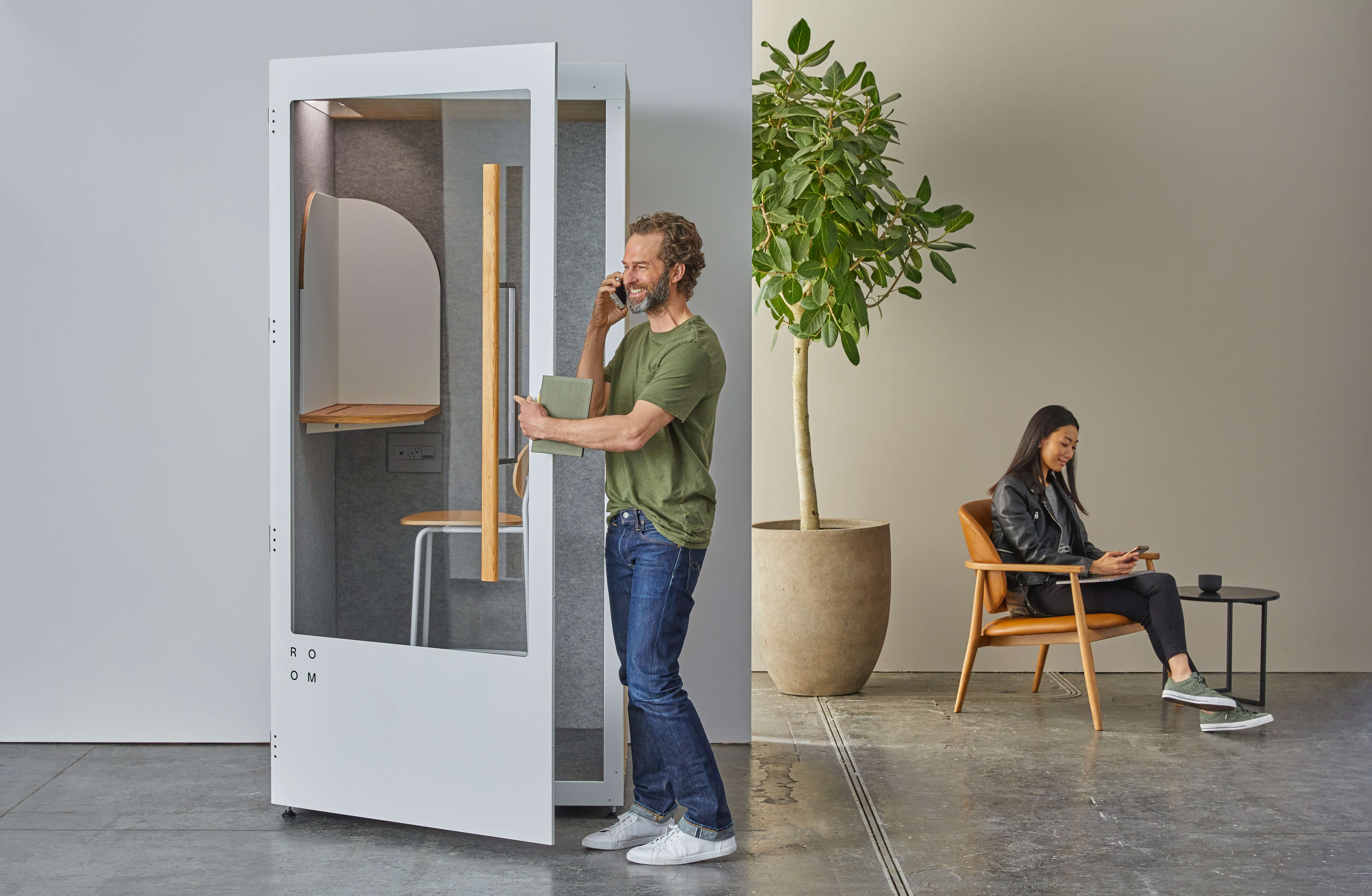 man on phone in acoustic office soundproof pod