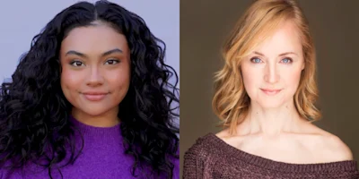 Two women pose side by side; the woman on the left has wavy dark hair and wears a purple sweater, while the woman on the right has straight blonde hair and wears a brown top.