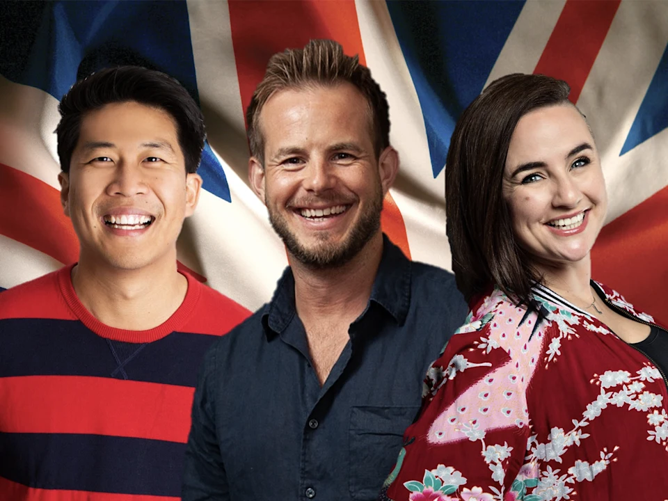 Three people smiling and standing in front of a large, unfurled British flag.