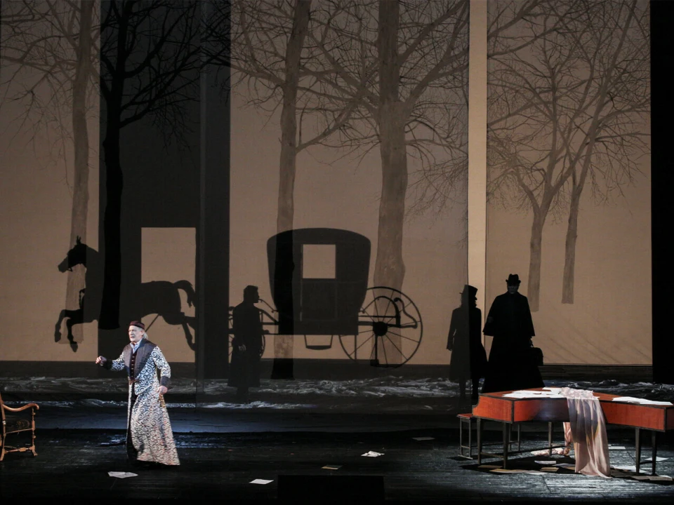 A stage scene with an actor in the foreground, a piano with sheet music, and a backdrop depicting silhouettes of trees, a horse, and a carriage.