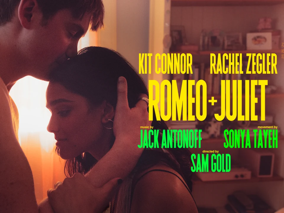 A man kisses the forehead of a woman who looks emotional. The text in the image lists actors Kit Connor and Rachel Zegler for the film "Romeo + Juliet" with music by Jack Antonoff and directed by Sam Gold.