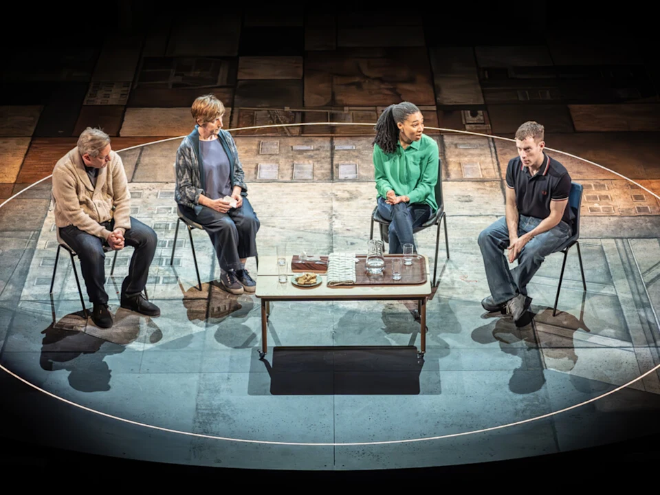 Tony Hirst, Julie Hesmondhalgh, Shalisha James-Davis and David Shields sit on chairs inside a circular stage with a table in the center in Punch on Broadway, New York City.