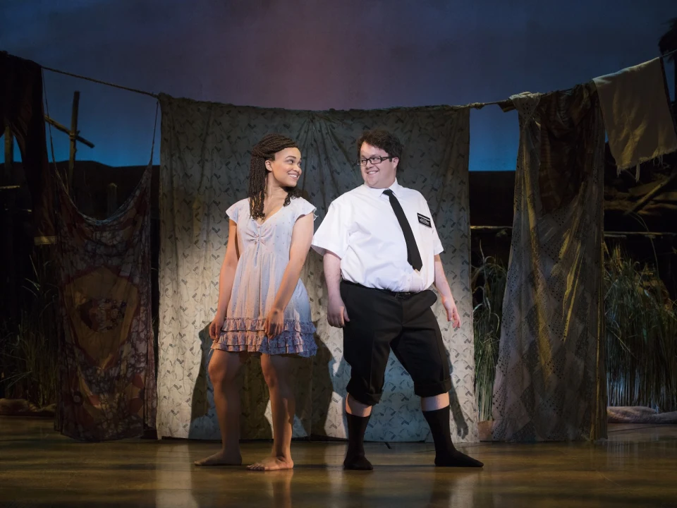 Production shot of The Book of Mormon in New York, with Cody Jamison Strand as Elder Cunningham and Kim Exum as Nabulungi.