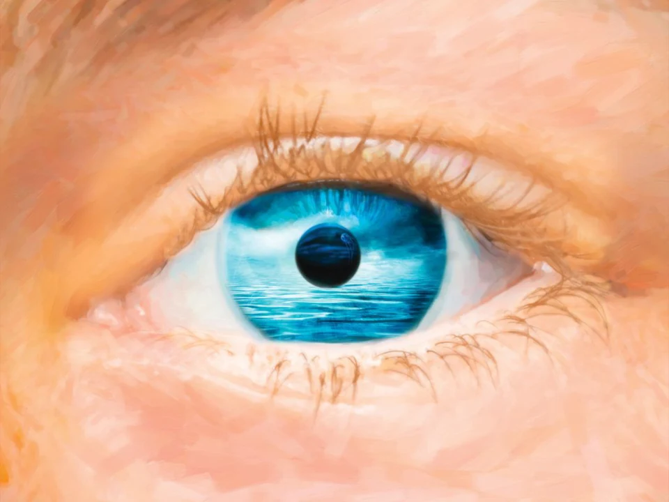 Close-up of a blue eye, with the reflection of an ocean and planet visible in the iris.