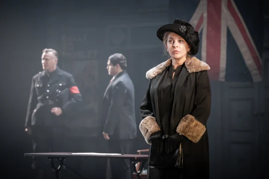 Production image of The Merchant of Venice in London, featuring Tracy Ann Oberman as Shylock with ensemble cast.