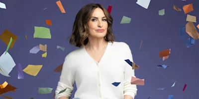 A woman with shoulder-length brown hair wearing a white sweater stands against a purple background with colorful paper pieces floating around her.