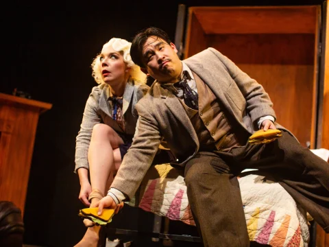 Production shot of The 39 Steps in San Francisco, showing struggle with a sandwich.