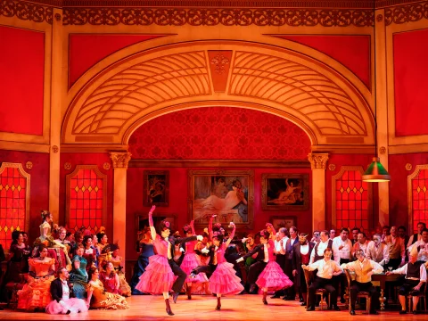 Production shot of La Traviata, showing ensemble dancing.