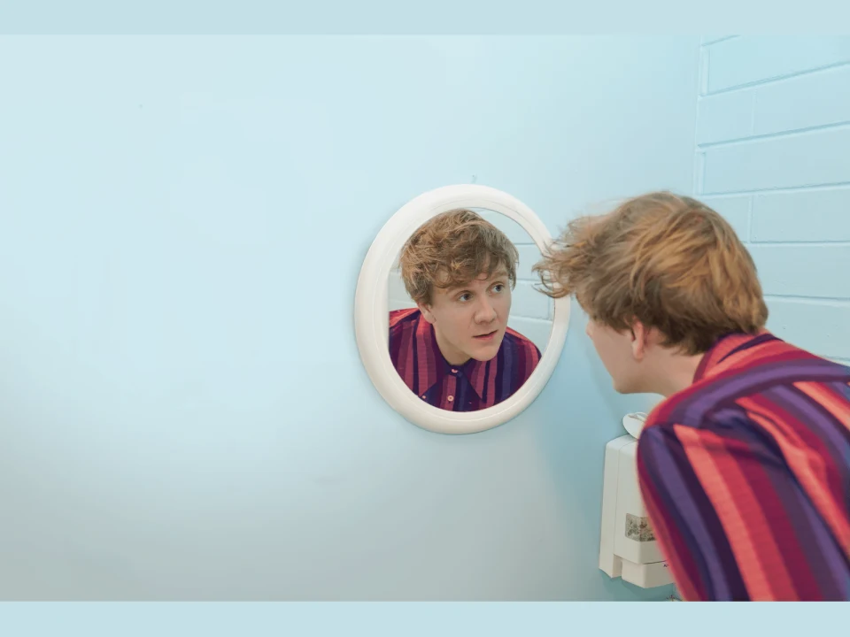 Production shot of Josh Thomas - Let's Tidy Up in NYC, showing man and the mirror.