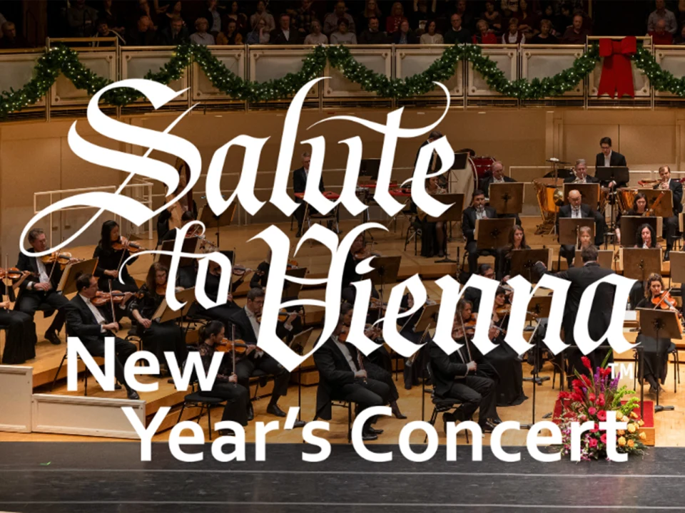 Orchestra performing on stage with holiday decorations, featuring text "Salute to Vienna New Year's Concert" overlayed prominently in the foreground.