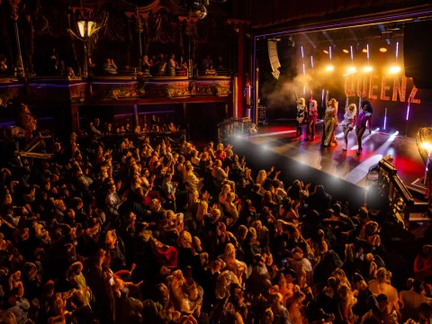 Production image of QUEENZ in London featuring the audience looking at the cast.