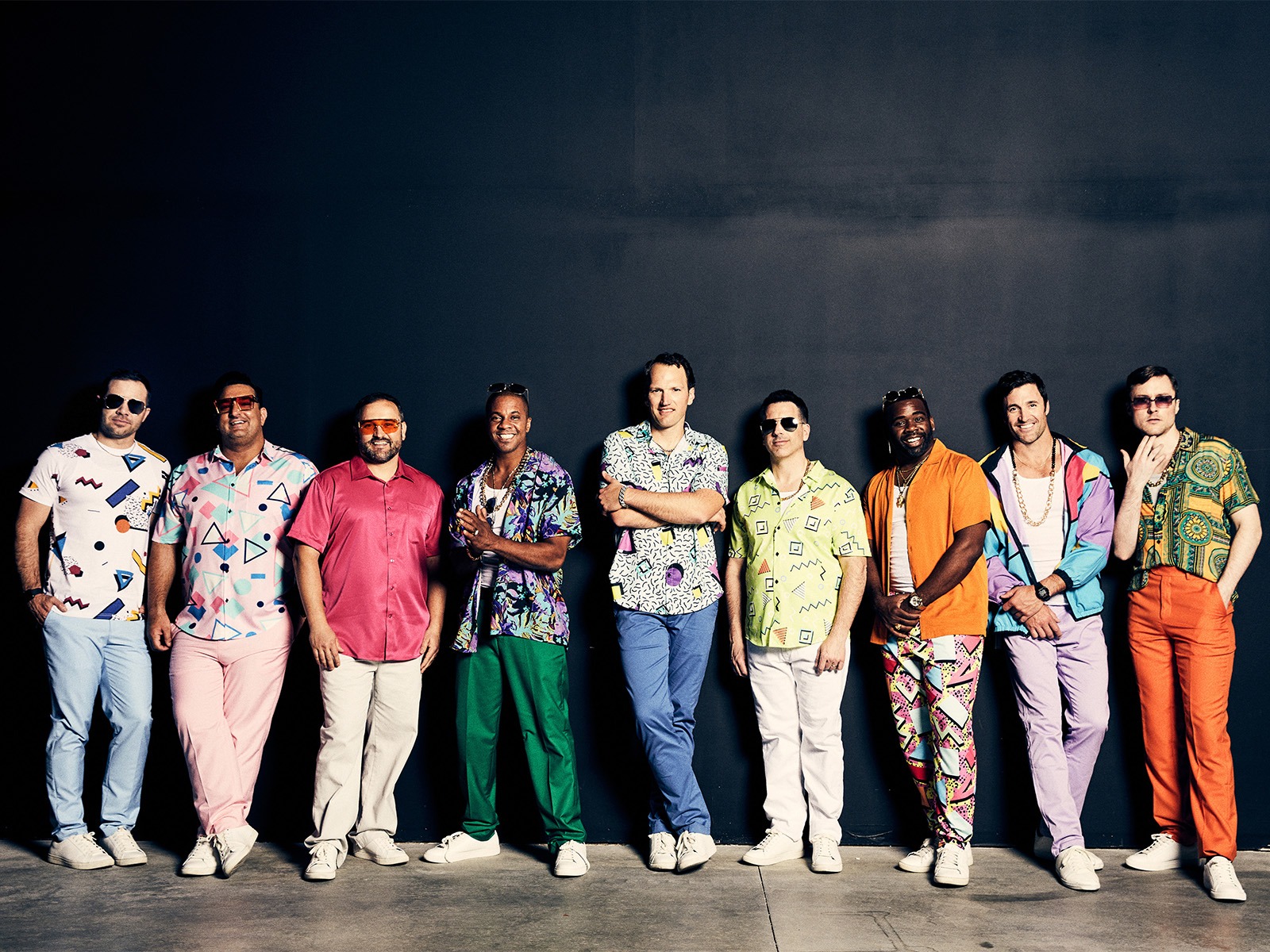 Performers of  Straight No Chaser in Washington DC, wearing colorful, patterned shirts, light pants, and white shoes.