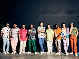 Performers of Straight No Chaser in Washington DC, wearing colorful, patterned shirts, light pants, and white shoes.