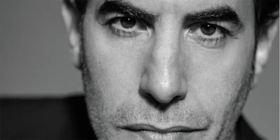 Black and white close-up portrait of Sacha Baron Cohen.