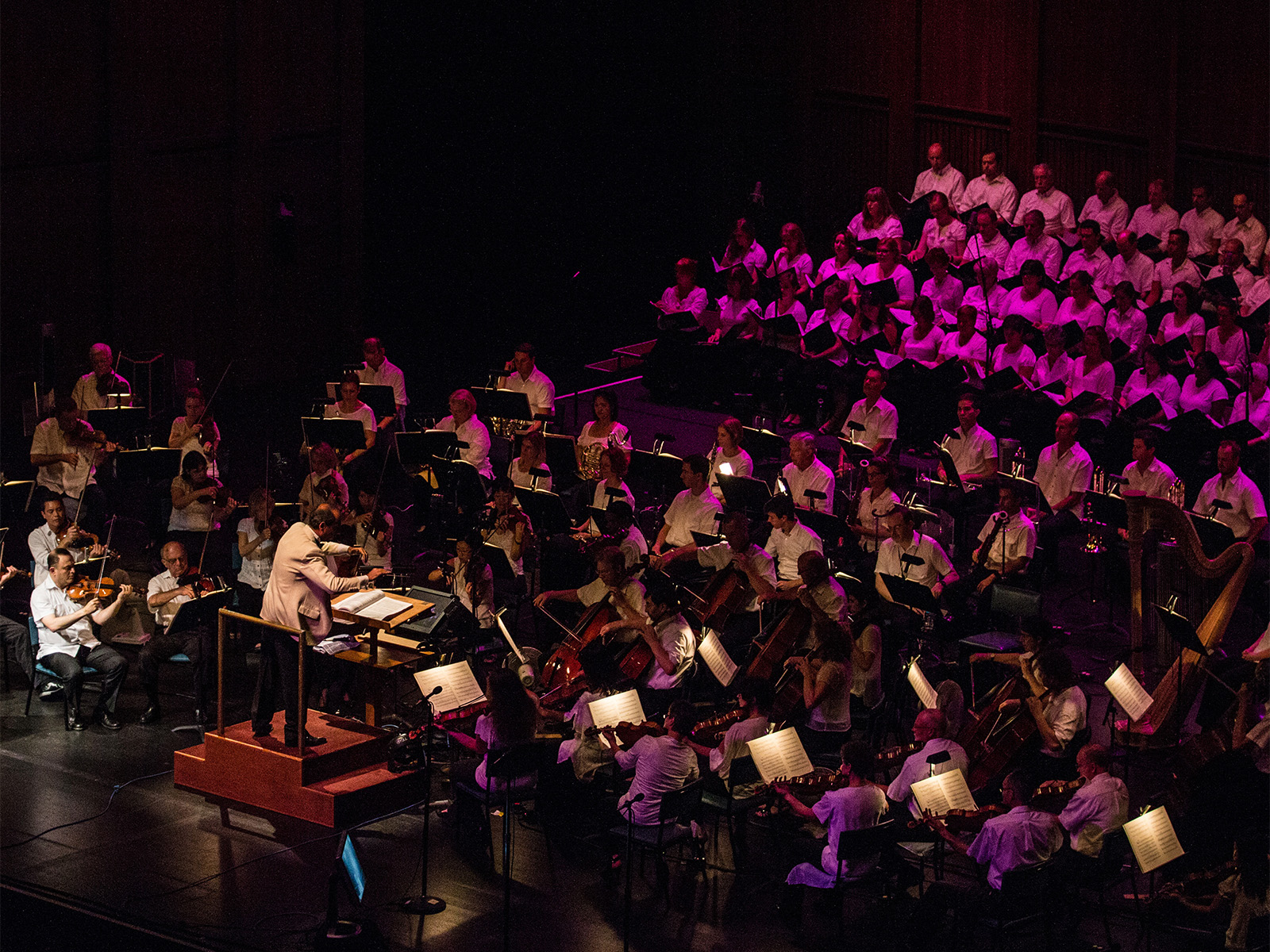 Production photo of Beethoven's Ninth Symphony National Symphony Orchestra in Washington, showing a conductor leads an orchestra and choir during a performance on stage.