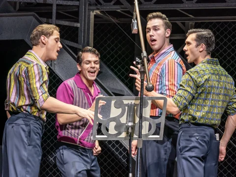 Production shot of Jersey Boys in London showing ensembles singing.