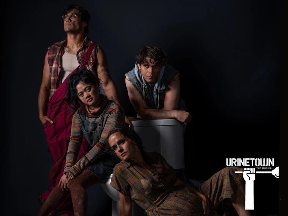Four people in ragged clothes pose dramatically around a toilet against a dark background. "Urinetown The Musical" logo is visible in the lower right corner.