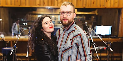 A woman and a man standing together in a recording studio.
