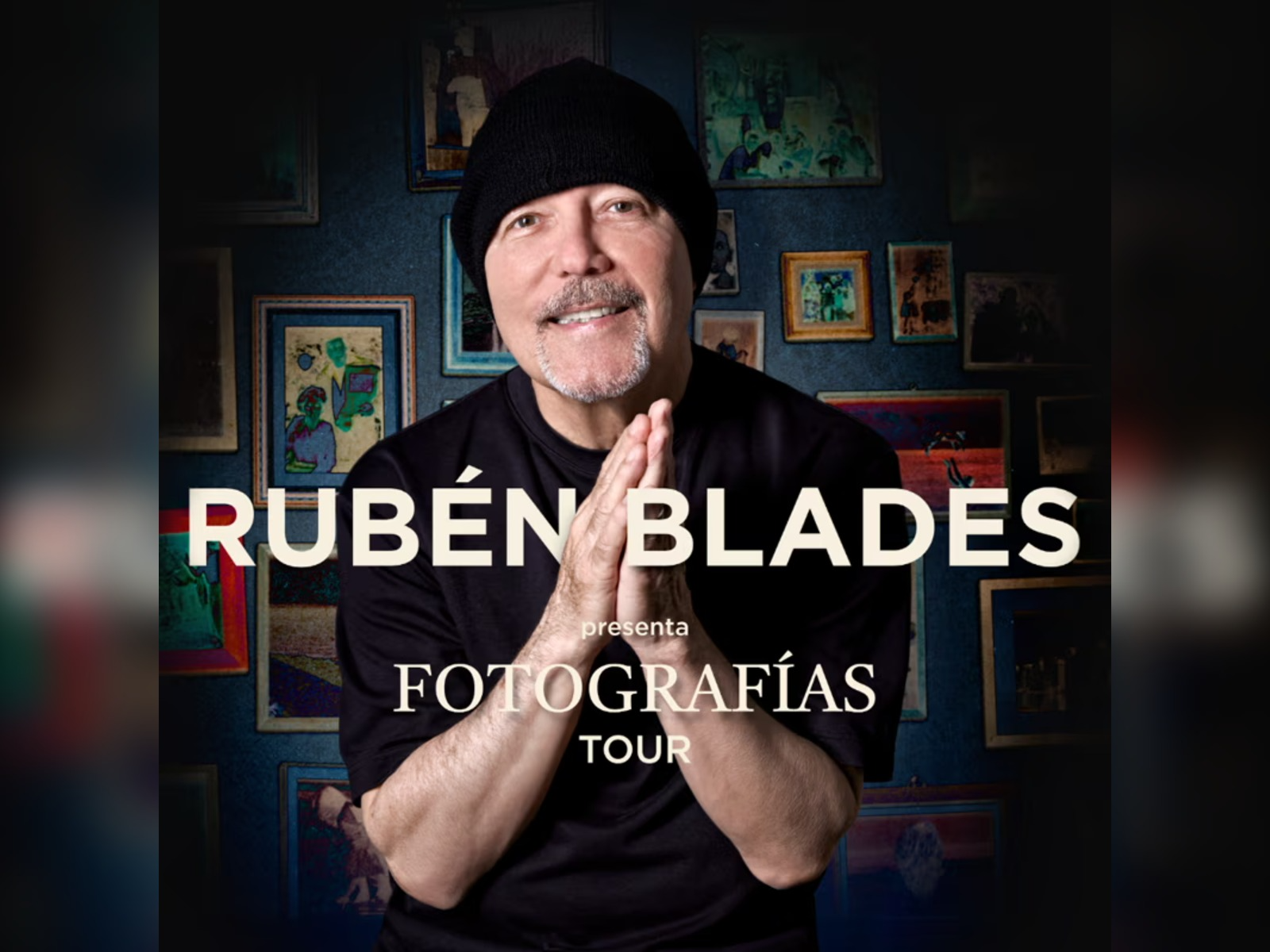 Rubén Blades smiles and clasps his hands in front of a wall with framed photos; text reads "Rubén Blades presenta Fotografías Tour.