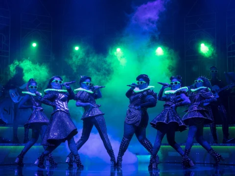 Production shot of SIX in New York, with the lead cast in their glitter and glam performance.