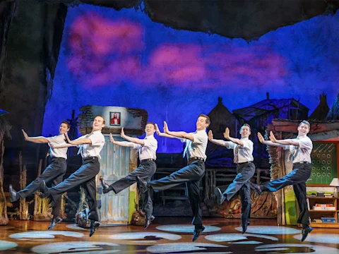 Production shot of The Book of Mormon in London featuring the 'Mormons' ensemble.