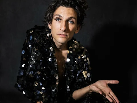 Photo of Morgan Bassichis wearing a black sequin jacket in Can I Be Frank?