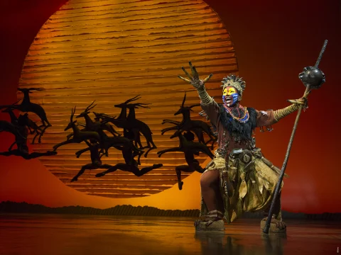 Production shot of The Lion King in New York, with Tshidi Manye as Rafiki.