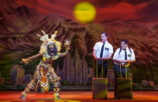 Production shot of The Book of Mormon in London, with Blair Gibson as Elder Price and Conner  Peirson as Elder Cunningham.