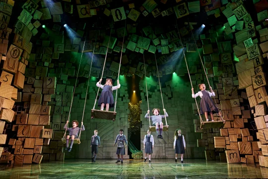 Production shot of Matilda The Musical in London, showing children on the swing.