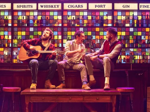 Production shot of The Choir of Man in London, showing cast singing.