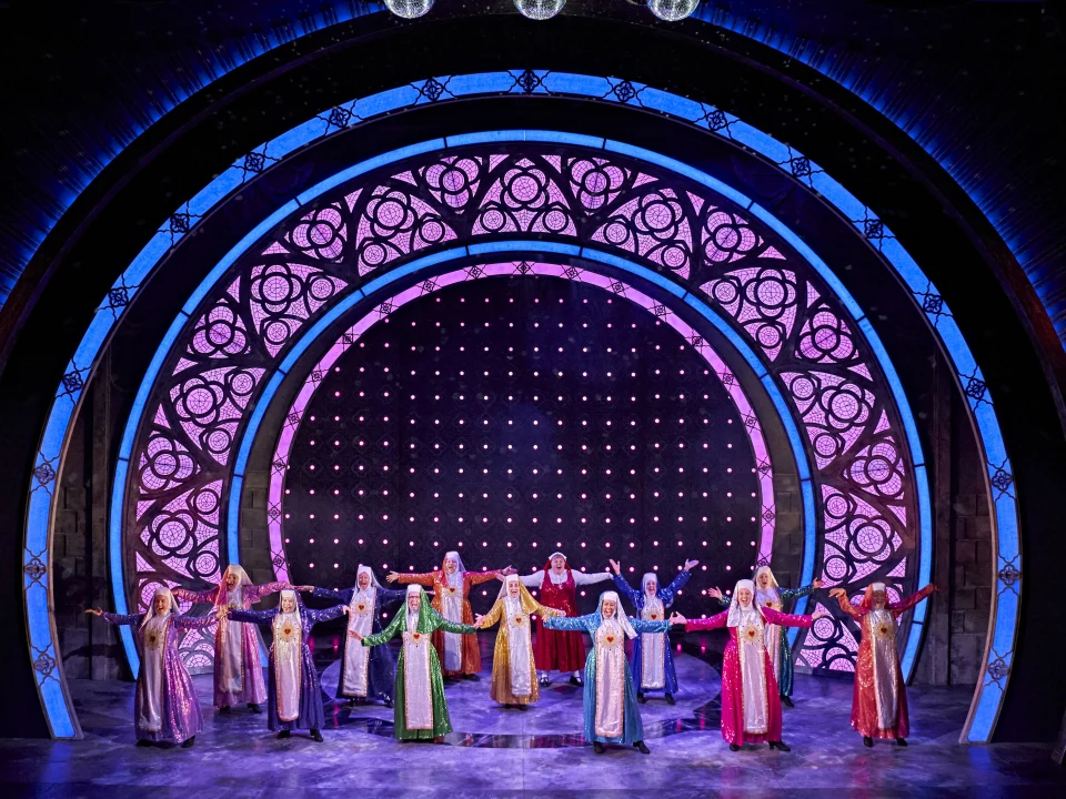 Production shot of Sister Act in London, showing cast singing.