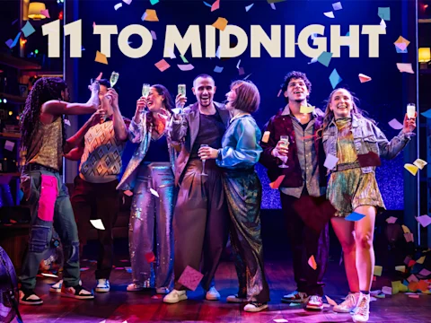 A group of seven people celebrate on stage under the text "11 TO MIDNIGHT," surrounded by confetti and colorful lighting.