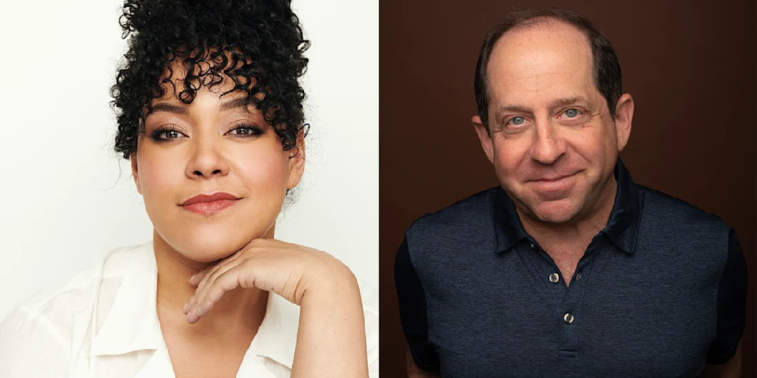 A woman with curly hair and a white shirt poses with her hand under her chin next to a man in a blue collared shirt, both facing the camera.