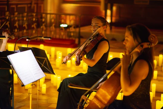 Production shot of Musicals by Candlelight in London showing ensembles holding their violins.