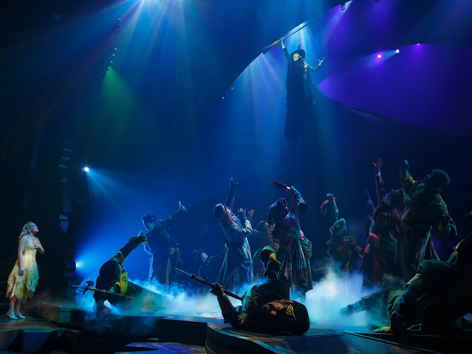 Production shot of Wicked in New York, showing an ensemble performing.