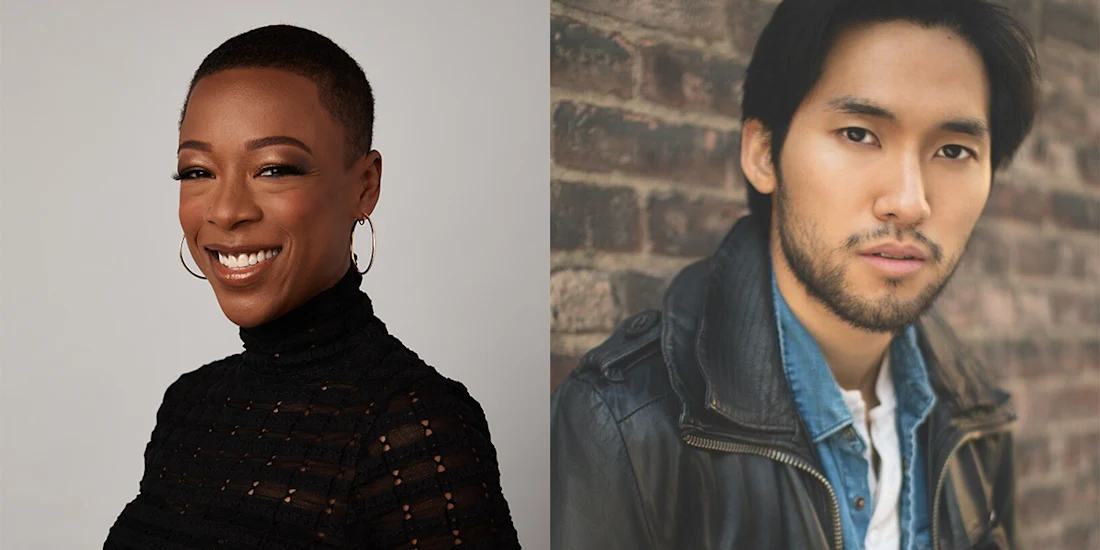 A woman with short hair smiles in a black top; next to her, a man with short hair and facial hair poses in a denim shirt and jacket against a brick wall.