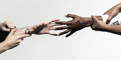 Two pairs of hands face each other; one pair light-skinned and one pair dark-skinned. Each reaches toward the other, with visible tattoos on the wrists.