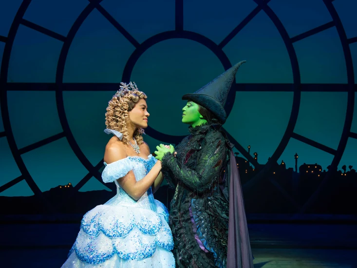 Production shot of Wicked in London with Lucy St. Louis as Glinda and Alexia Khadime as Elphaba.