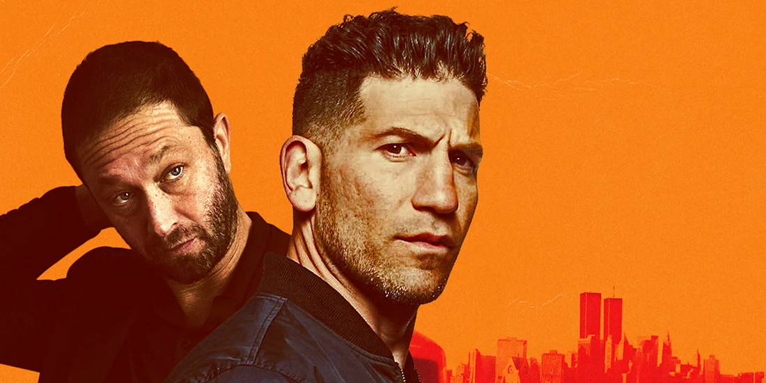 Two men stand in front of an orange background with a city skyline silhouette; one looks serious at the camera while the other looks to the side with his hand behind his head.