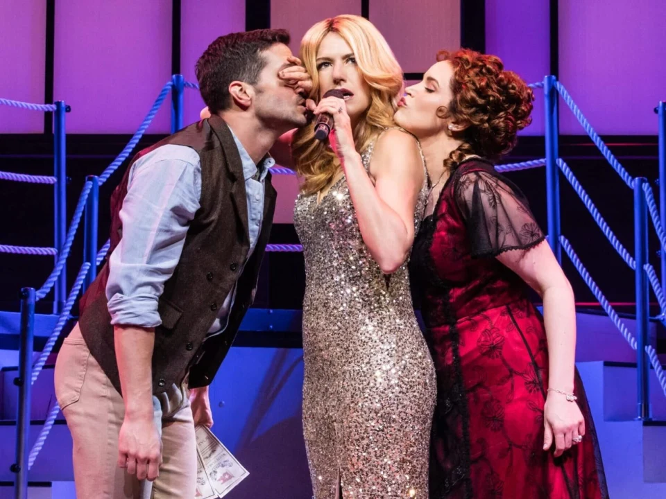 Production shot of Titanique in New York, with Michael Williams as Jack, Jackie Burns as Céline Dion, Lindsay Heather Pearce as Rose.