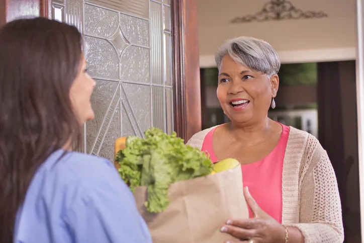 Volunteerism: Senior adult woman receives groceries at home