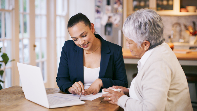 A patient advocate is helping an older patient with medical paperwork.