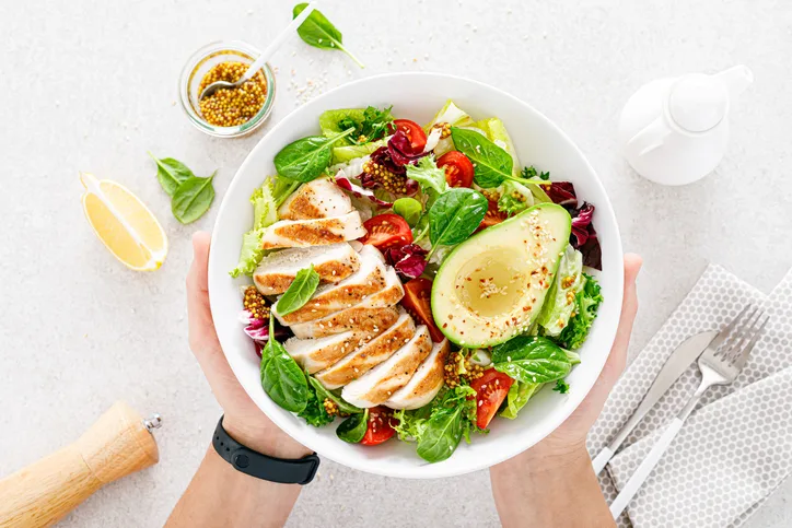 Healthy salad plate with grilled chicken and fresh vegetables.