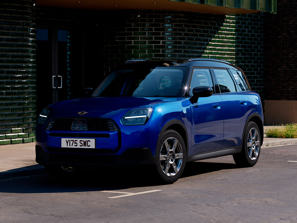 Blue MINI Countryman parked on the side of the street, with a glazed brick building in the background