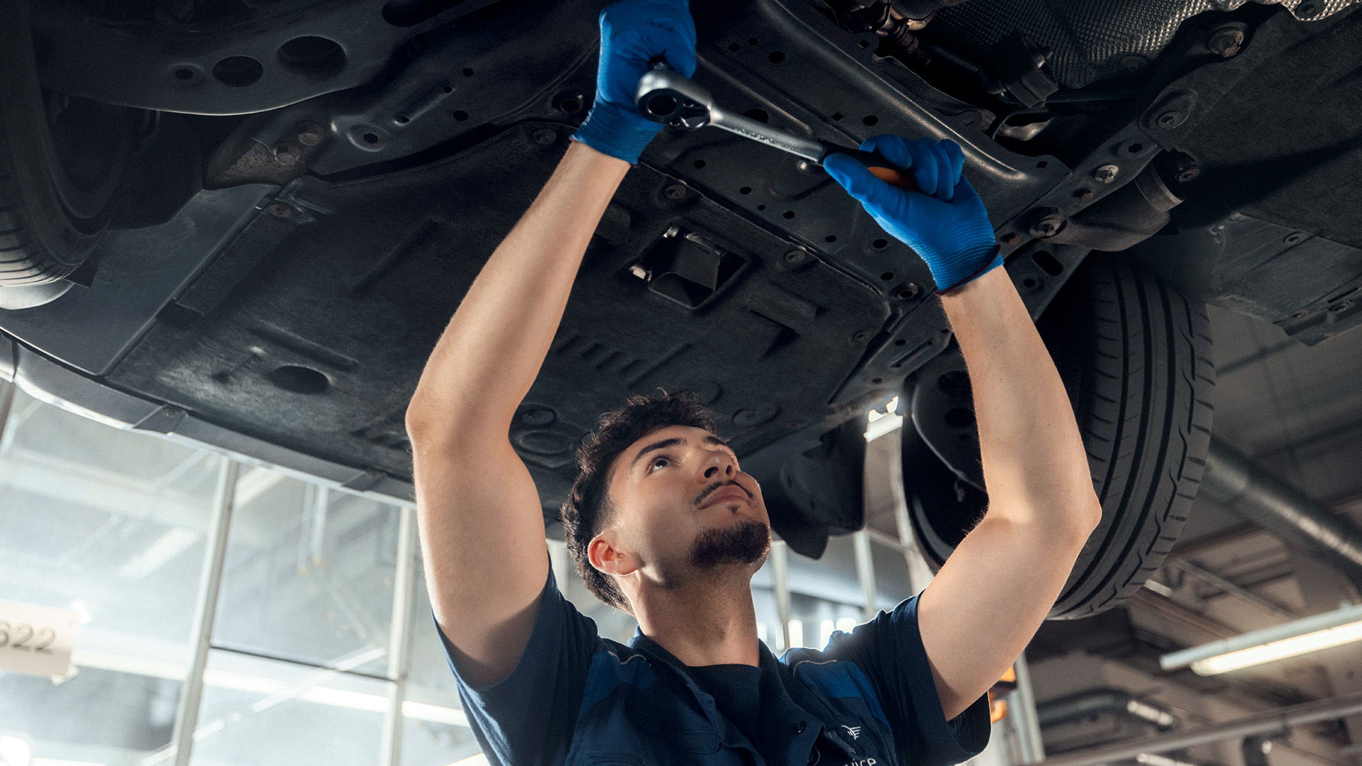 Mechanic working under a car lifted on a car lift