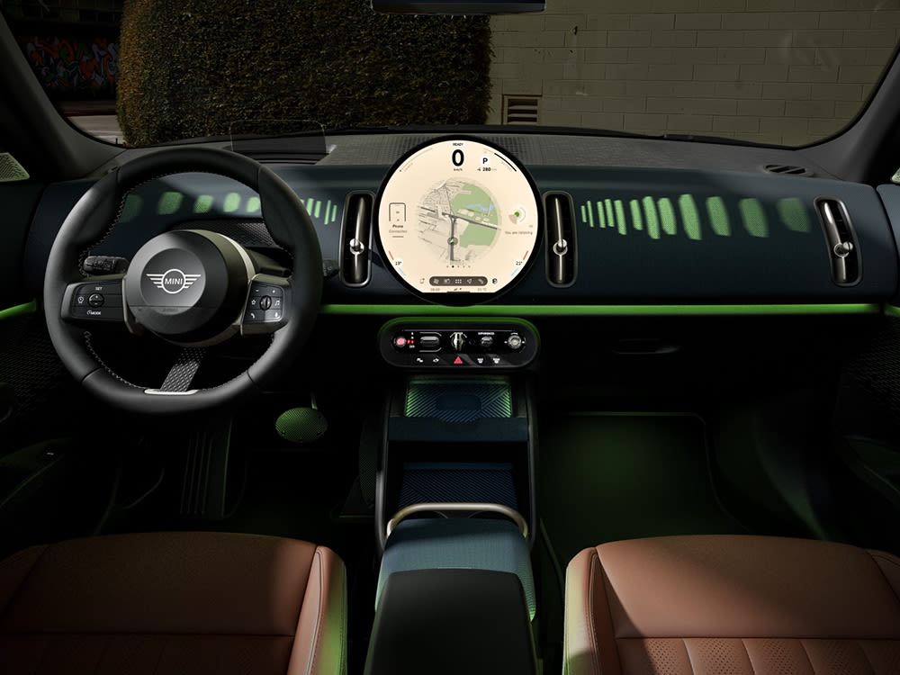 MINI interior showing a circular digital display with navigation map and vehicle information.