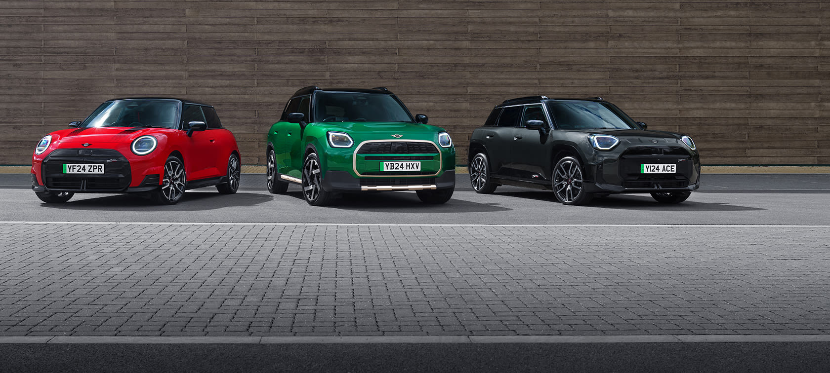 Three MINI cars parked side by side in red, green, and black.